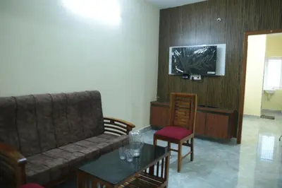 a living room with a couch and a table at Thulir Homestay Valparai in Vālpārai
