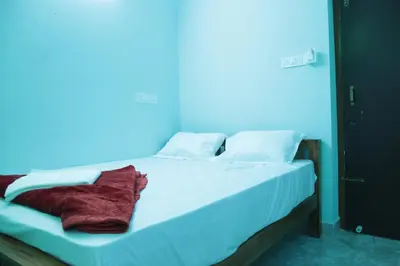 a bed in a room with a blue background at Thulir Homestay Valparai in Vālpārai
