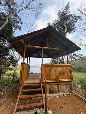 a wooden structure with a roof on top at carpa lupa 1 waterfront bamboo cottage wayanad in Meenangadi
