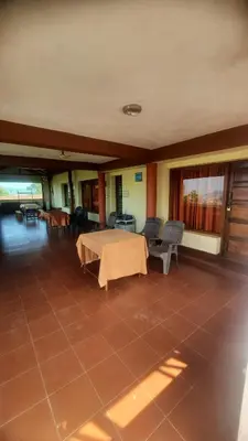 a room with a table and chairs on a tiled floor at Roshan Homestay in Madikeri
