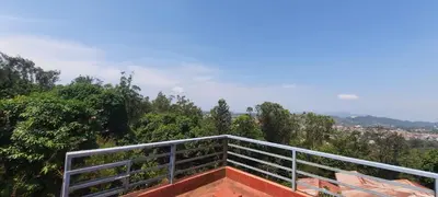 a balcony with a view of trees and a city at Roshan Homestay in Madikeri