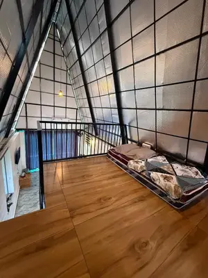 an attic room with a bed and a wooden floor at Zerahs Villa - Athirappilly - Extra upstair Bed space in Athirappilly