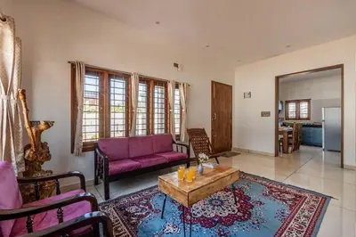 a living room with a purple couch and a coffee table at White Meadows Mysore in Mysore