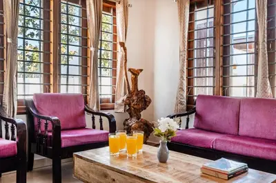 a living room with two purple couches and a coffee table at White Meadows Mysore in Mysore