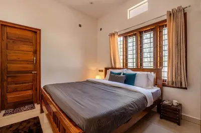 a bedroom with a bed and a window at White Meadows Mysore in Mysore