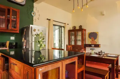 a kitchen with a refrigerator and a table in it at House StoneHaven in Kaniyāmbetta