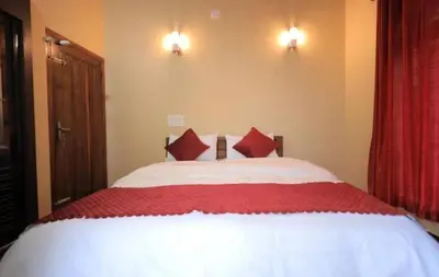 a bedroom with a large bed with red pillows at Hamai town villa in Ambalavayal
