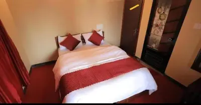 a bedroom with a bed with red and white sheets at Hamai town villa in Ambalavayal