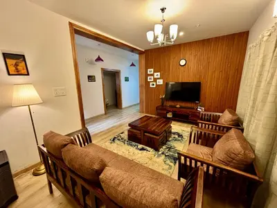 a living room with a couch and a television at Easters home in Kotagiri
