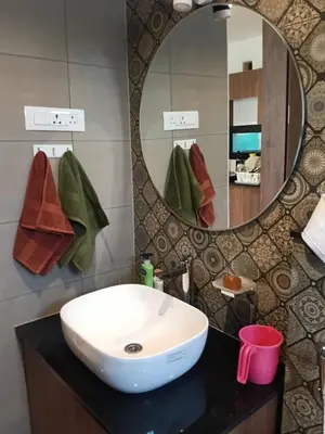 a bathroom with a white sink and a mirror at Rajarajeshwari Farm Stay in Sivasamudram
