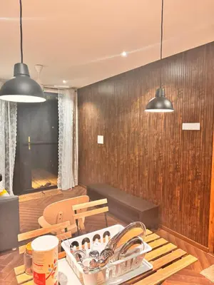a kitchen with wooden walls and two pendant lights at Rajarajeshwari Farm Stay in Sivasamudram