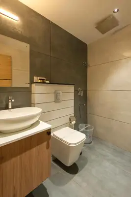 a bathroom with a white toilet and a sink at The Continental Suites in Kozhikode