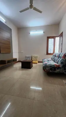 a living room with a couch and a ceiling fan at Aasana A tranquil space by the hills in Mysore