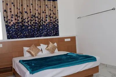 a bedroom with a bed with a blue blanket on it at Angels Nest 3BR FF near Karlad Lake by Homeyhuts in Padinjarathara
