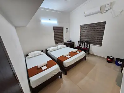a small room with two beds and a window at Guruvayur Nest Homestay Duo in Guruvāyūr