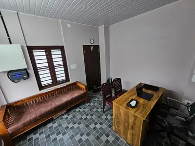 a living room with a couch and a table at Guruvayur Nest Homestay Duo in Guruvāyūr
