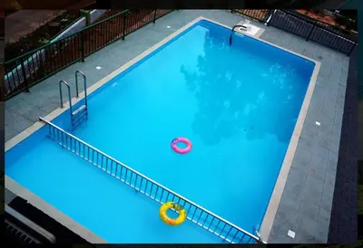 an overhead view of a large blue swimming pool at Nature Quite in Vattavada