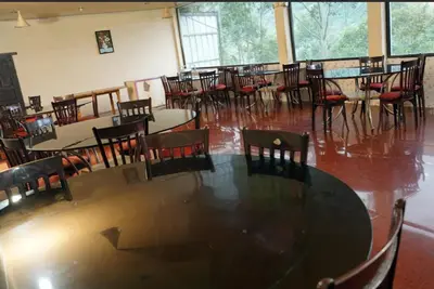 a dining room with tables and chairs in a room at Nature Quite in Vattavada