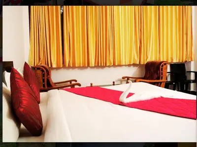 a bedroom with two beds with red and white sheets at Nature Quite in Vattavada