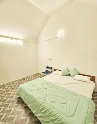 a bedroom with a large bed with a green blanket at Canvo Vattavada in Vattavada