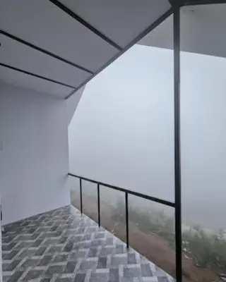 an empty room with a balcony with a view at Canvo Vattavada in Vattavada