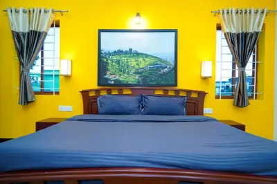 a yellow bedroom with a bed and a painting on the wall at Nature'call homestay in Ooty