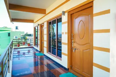 a room with a balcony with a door and a view at Nature'call homestay in Ooty