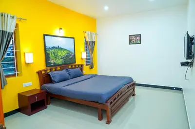 a bedroom with a bed in a yellow wall at Nature'call homestay in Ooty