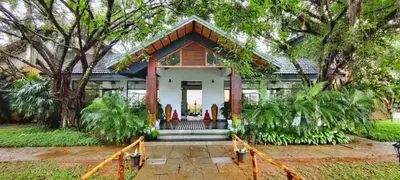 a small house with a porch and trees at Misty Grove Resort, Gudalur in Devāla