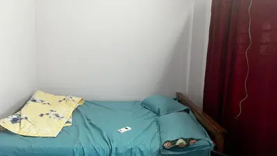 a small bed in a corner of a room at Aneesh Arcade in Kollengode