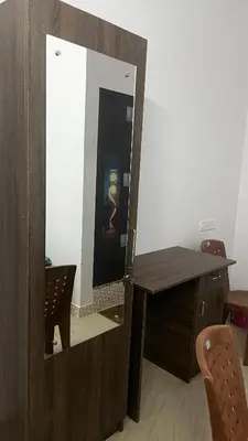 a mirror in a room with a table and a desk at Aneesh Arcade in Kollengode