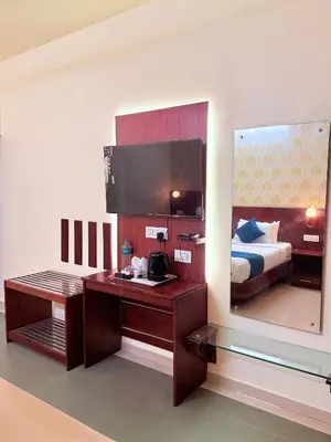 a hotel room with a desk and a bed at Vythiri Greens Holiday Resorts in Vythiri