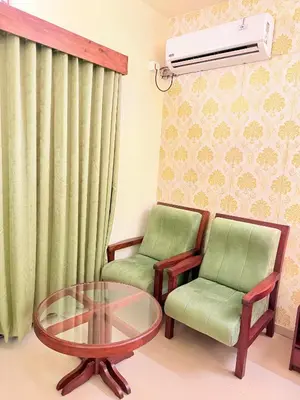 a living room with two chairs and a glass table at Vythiri Greens Holiday Resorts in Vythiri
