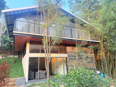 a house with a balcony on the side of it at Vythiri Greens Holiday Resorts in Vythiri