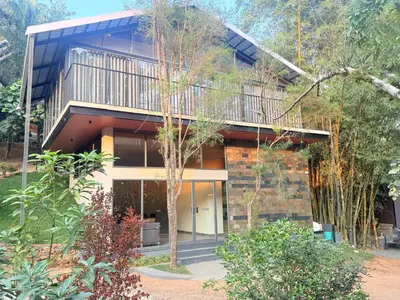 a house with a balcony on top of it at Vythiri Greens Holiday Resorts in Vythiri