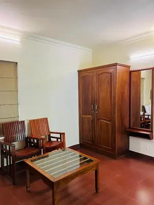 a living room with a wooden cabinet and a coffee table at Vythiri Greens Holiday Resorts in Vythiri