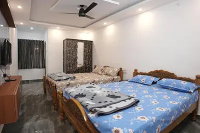 a bedroom with two beds and a ceiling fan at River view farm stay in Anaimalai