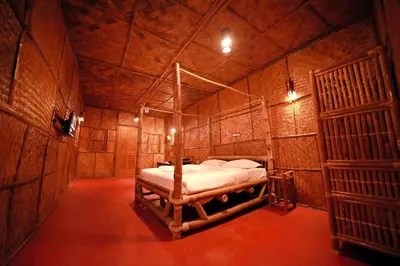 a bedroom with a bed in a wooden room at Bali Bamboo Resort in Padinjarathara