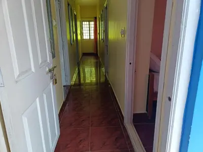 a hallway with yellow and green walls and a tile floor at Yamuna cottage in Ooty