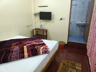 a bedroom with a bed and a bathroom with a television at Yamuna cottage in Ooty