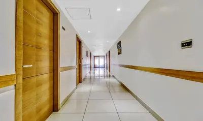 a corridor of an office building with wooden walls and a long hallway at Medora Hotel by Rak Rooms in Kozhikode