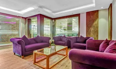 a living room with purple couches and a table at Medora Hotel by Rak Rooms in Kozhikode