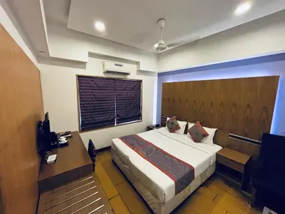 a bedroom with a bed and a desk and a window at Medora Hotel by Rak Rooms in Kozhikode