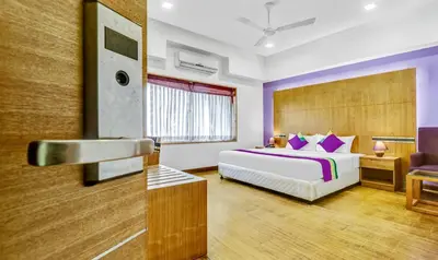 a hotel room with a bed and a sink at Medora Hotel by Rak Rooms in Kozhikode