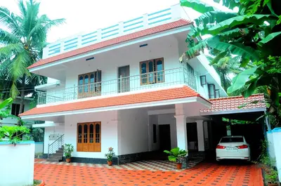 a white house with a car parked in front of it at Grace Guest Home in Trichūr