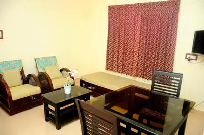 a living room with a couch and a table and chairs at Grace Guest Home in Trichūr