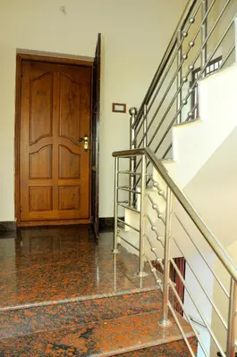 a staircase leading to a wooden door in a house at Grace Guest Home in Trichūr