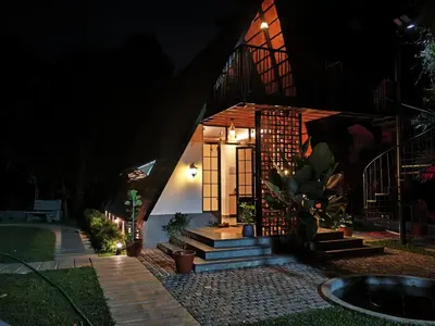a house with a staircase leading to a door at night at Whispering Bamboos Attapadi Palakkad in Palakkad