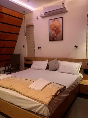 a bedroom with a large bed with white sheets at Whispering Bamboos Attapadi Palakkad in Palakkad