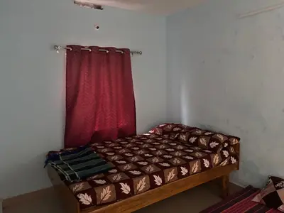 a bed in a room with a red curtain at The Retreat in Vālpārai